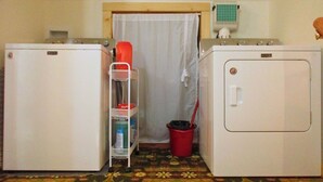 A laundry room with two washing machines, a drying rack, and a bucket. - The Loft at Aspen Pine with Wi-Fi, AC in wonderful Hot Springs (Hot Springs)