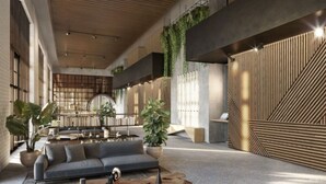 Un hall d’entrée spacieux au design moderne, comprenant un canapé, une table basse et des plantes en pot.