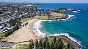 Une ville côtière dotée d’une plage, offrant une vue sur l’océan et comprenant des immeubles résidentiels.