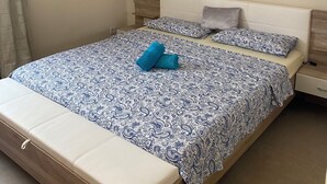A bedroom with a large bed, a wooden headboard, and a nightstand with a lamp. - Luxury Paradise Beach Lagoon (Boa Vista)