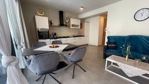 A modern living room with a dining area, a kitchen, and a sofa. - Luxury Paradise Beach Lagoon (Boa Vista)