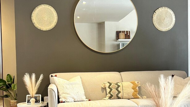 A modern living room with a grey sofa, round mirrors, and decorative items. - Taxqueño Charm  (Taxco de Alarcón)