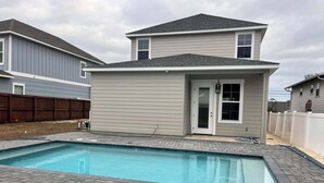 Ein Wohnhaus mit Swimmingpool, einem zweigeschossigen Haus und einem eingezäunten Garten.