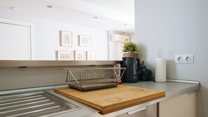 A modern kitchen with a wooden countertop, a stainless steel sink, and a drying rack. - 2BR Penthouse in downtown with sunny terrace (Sevilla)
