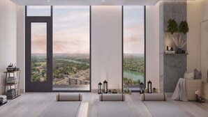 A modern room with large windows, a view of a cityscape, and minimalist decor. - Rainey St LuxuryCondo w/ Balcony (Austin)
