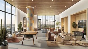 A spacious, modern living area with a large wooden ceiling, a central column, and a large window offering a city view. - Rainey St LuxuryCondo w/ Balcony (Austin)