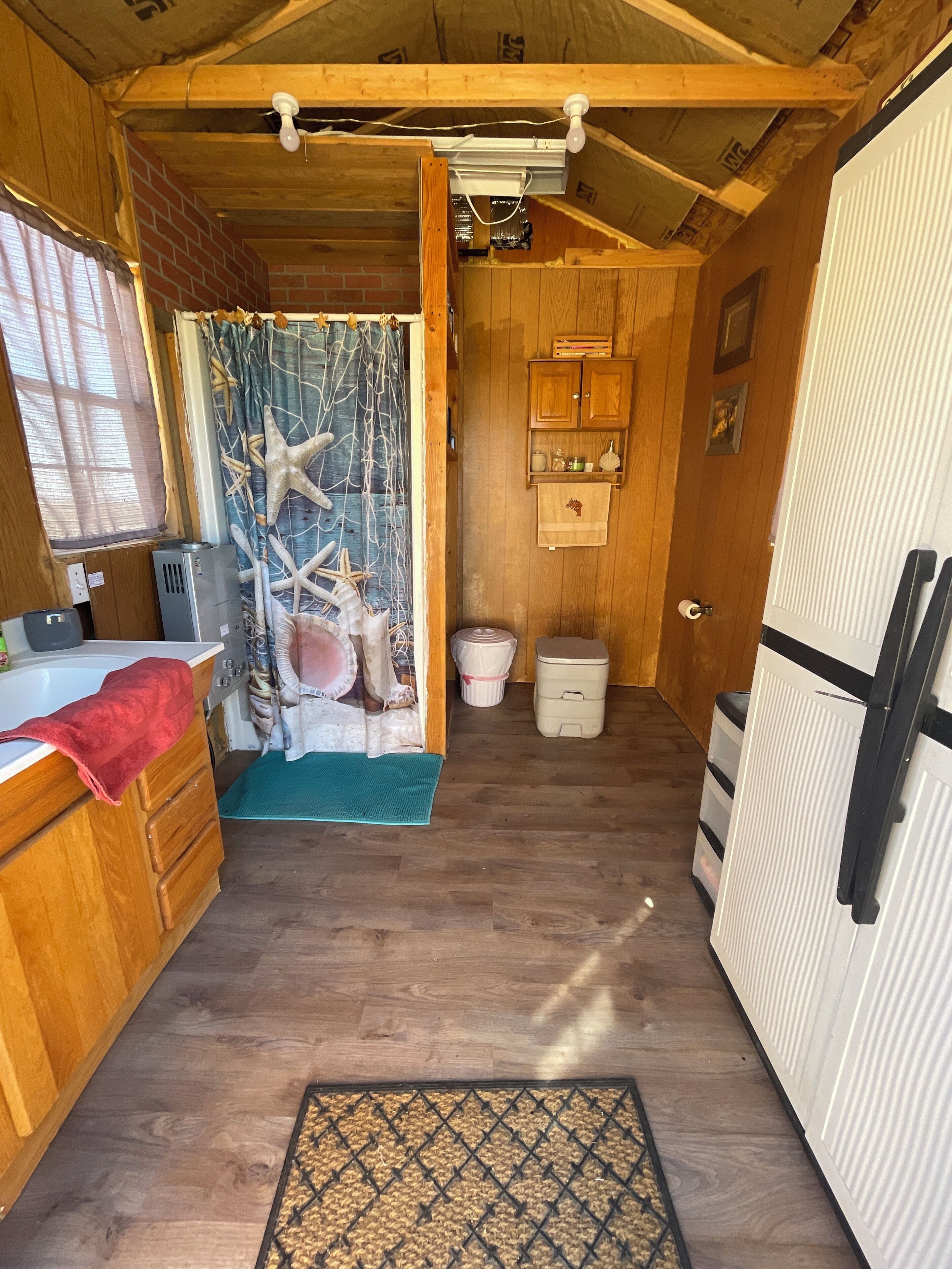 A compact kitchen with wooden cabinets, a sink, and a countertop.