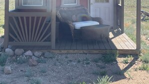 A small, single-story wooden cabin with a porch, two windows, and a door. - Terrific 1-bedroom off grid cabin in Belfry with Mountain View (Belfry)