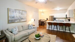 A modern living room with a sofa, coffee table, and a painting on the wall.
