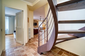 A staircase with a metal railing leading to a landing. - GuestHost - Cozy apartment of 72 sqm, sleeping 6 people, on the 1st floor of a period building (NO lift and STAIRS to access) with access to the roof terrace offering a panoramic view over the city.We are located in the heart of Assisi (ZTL - Restricted (Assisi)
