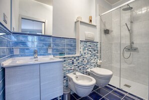 A modern bathroom with a shower, bidet, and a sink. - GuestHost - Cozy apartment of 72 sqm, sleeping 6 people, on the 1st floor of a period building (NO lift and STAIRS to access) with access to the roof terrace offering a panoramic view over the city.We are located in the heart of Assisi (ZTL - Restricted (Assisi)