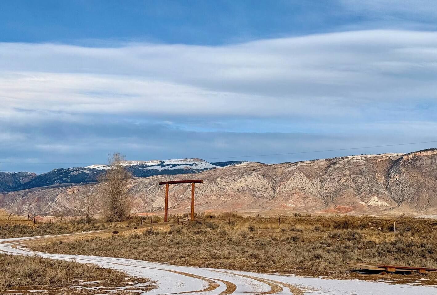 Una carretera sinuosa atraviesa un paisaje montañoso bajo un cielo despejado.