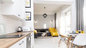 Una cocina moderna con armarios blancos, una encimera de madera y una cafetera.