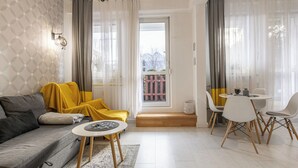 Una sala moderna con sofá, mesa de centro y comedor con sillas.
