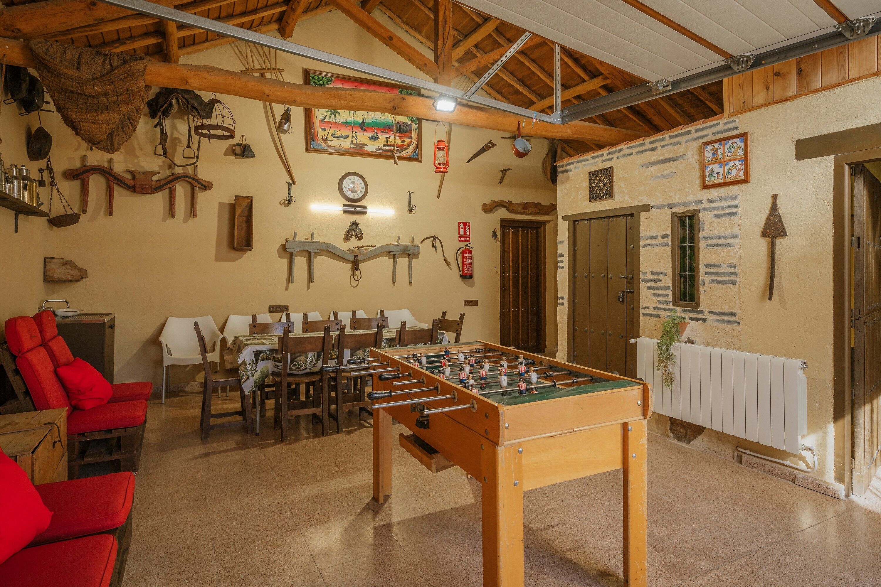Une pièce équipée d’un baby-foot, de meubles en bois et de différents éléments de décoration murale.