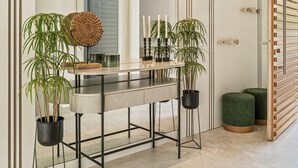 A modern interior with a reflective surface, a wooden sideboard, potted plants, and a unique wooden slatted wall. - Villa '11 Sunset' with Mountain View, Wi-Fi and Air Conditioning (Marbella)