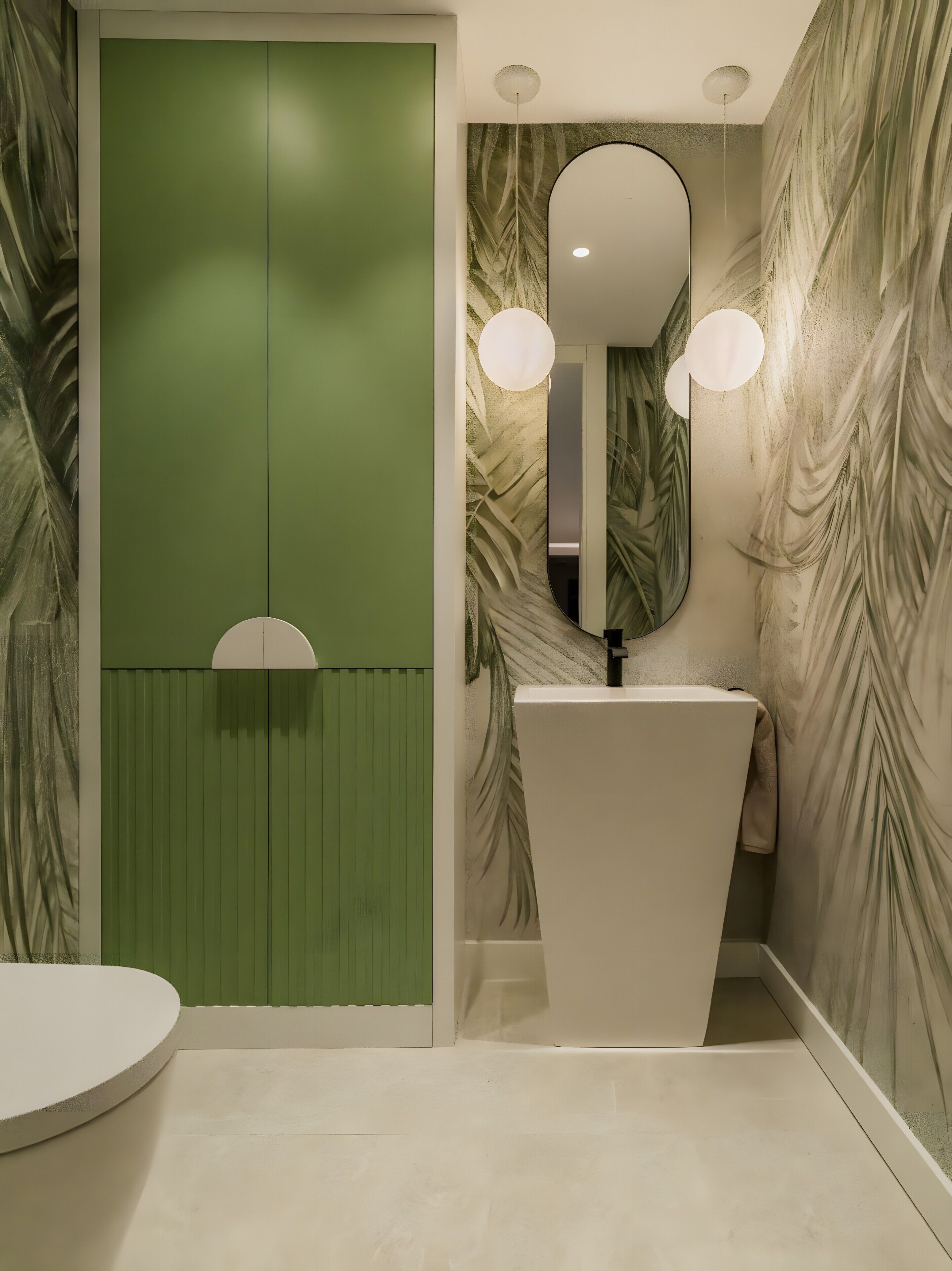 A bathroom with a green accent wall, a white sink, a mirror, and two wall-mounted lights.