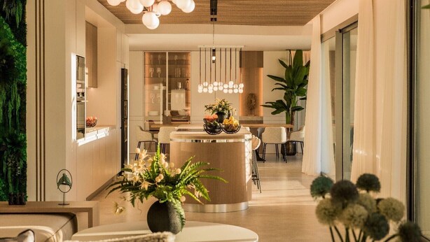 A modern interior with a central round table, seating, a hanging light fixture, and a green wall feature. - Villa '11 Sunset' with Mountain View, Wi-Fi and Air Conditioning (Marbella)