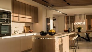 A modern kitchen with a central island, built-in appliances, and a pendant light fixture. - Villa '11 Sunset' with Mountain View, Wi-Fi and Air Conditioning (Marbella)