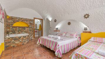 Un dormitorio con pared de ladrillo, techo blanco y cama amarilla.