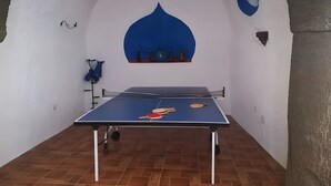 A ping pong table in a room with white walls, a blue accent wall, and a tiled floor. - Country House 'Los Jazmines' with Shared Pool, Wi-Fi and Air Conditioning (Benalúa)