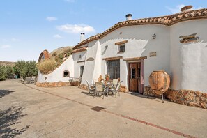 A traditional building with a patio, outdoor seating, and a large pot. - Country House 'La Chumbera' with Mountain View, Wi-Fi and Air Conditioning (Benalúa)