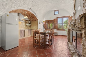 Una cocina amplia con una isla central, armarios de madera y una chimenea de piedra.