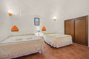 A hotel room with two beds, a nightstand, a lamp, a picture on the wall, and a wardrobe. - Country House 'El Granado' with Shared Pool, Wi-Fi and Air Conditioning (Benalúa)