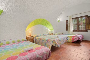 A cozy bedroom with two beds, a window with curtains, and a tiled floor. - Country House 'El Granado' with Shared Pool, Wi-Fi and Air Conditioning (Benalúa)