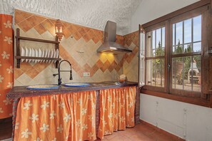 A kitchen with a herringbone tile backsplash, a gas stove, and a window with a view of the outdoors. - Country House 'El Granado' with Shared Pool, Wi-Fi and Air Conditioning (Benalúa)