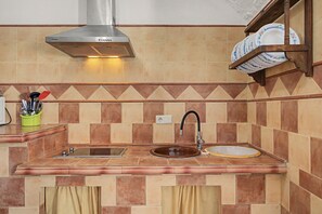 A kitchen with a stainless steel range hood, a double sink, and a dish rack with plates. - Country House 'El Olivo' with Shared Pool, Wi-Fi and Air Conditioning (Benalúa)