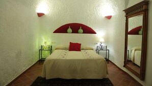 Ein Schlafzimmer mit einem Bett, einem Spiegel und zwei Nachttischen.
