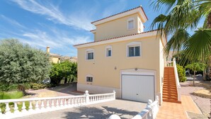 A two-story building with a white balcony, a garage, and a staircase leading to the upper floor. - Holiday Home 'Limonita' with Private Pool, Wi-Fi and Air Conditioning (Mutxamel)
