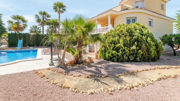 A two-story house with a swimming pool, palm trees, and a well-maintained garden. - Holiday Home 'Limonita' with Private Pool, Wi-Fi and Air Conditioning (Mutxamel)