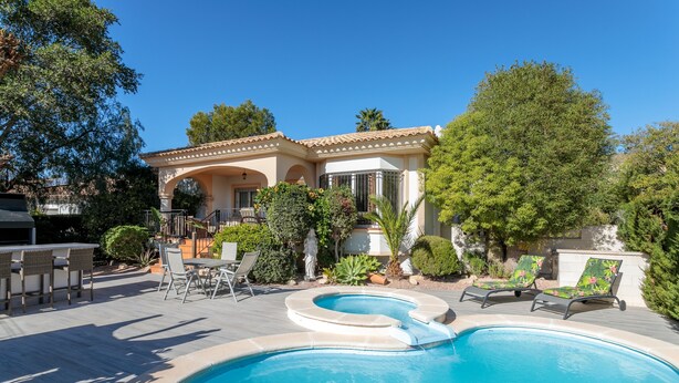 A swimming pool with lounge chairs, a covered patio, and a house with a tiled roof. - Villa 'Los Naranjos' with Private Pool, Wi-Fi and Air Conditioning (Mutxamel)