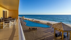 A poolside area with a view of the ocean, lounge chairs, and a gazebo. - Treasure Island 312 | Elite 3BR View (Panama City)