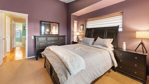 Un dormitorio con cama, cómoda, mesita de noche y un espejo grande.