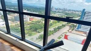 A room with a large window overlooking a cityscape.