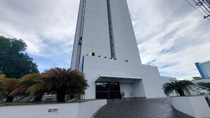 Un immeuble moderne et imposant, doté d’une entrée remarquable et d’une zone pavée devant.
