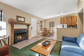 Una sala de estar con chimenea, un comedor y una cocina.