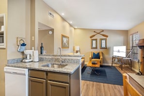 A compact kitchen with a built-in dishwasher, a sink, and a countertop.