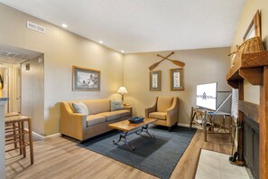 Una sala de estar acogedora con un sofá, sillones, una mesa de centro y una chimenea.