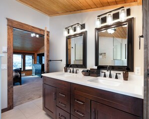 A bathroom with a double vanity, two large mirrors, and a wooden ceiling. - SPACIOUS & Stunning 6-bedroom Log Cabin Home Great for Large Gatherings! (Emigrant)