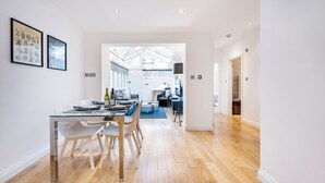 A modern kitchen with a dining area, wooden flooring, and a view into the living room. - 2Bedr/3Beds/2Bath Covent Garden 3min subway (London)