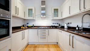 A modern kitchen with white cabinets, a stainless steel range hood, and a wooden floor. - 2Bedr/3Beds/2Bath Covent Garden 3min subway (London)