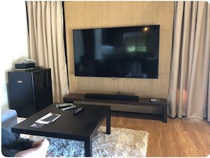 Relax in this stylish living room with a flat-screen TV, entertainment unit, and comfortable seating area.