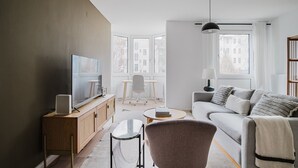 A modern living room with a TV, sofa, and coffee table.