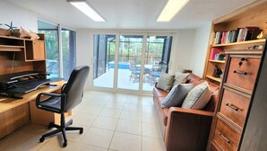 Ein Arbeitszimmer mit Schreibtisch, Stuhl und Bücherregal.