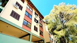 Un edificio de varios pisos con techo plano y zona de estacionamiento techada.