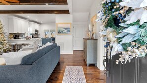A modern living room with a grey sofa, a wooden ceiling, and a decorated Christmas tree. - French Country Retreat Near Ball Ground Weddings, girls getaway. Quiet retreat!  (Ball Ground)